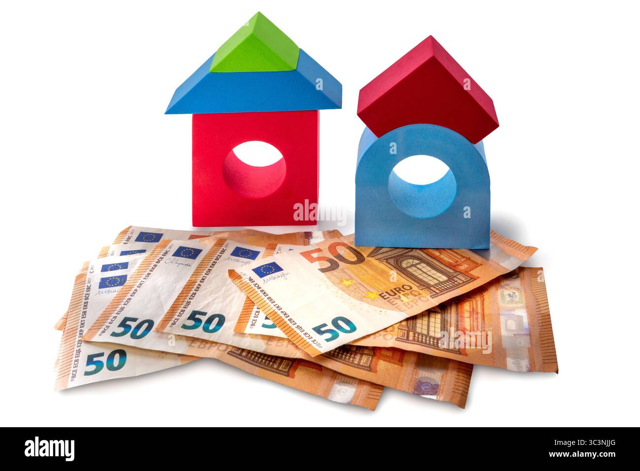Maisons de briques jouets multicolores sur cinquante billets en euros isolés sur blanc avec chemin de découpage inclus, concept de coût d'achat de la maison Banque D'Images