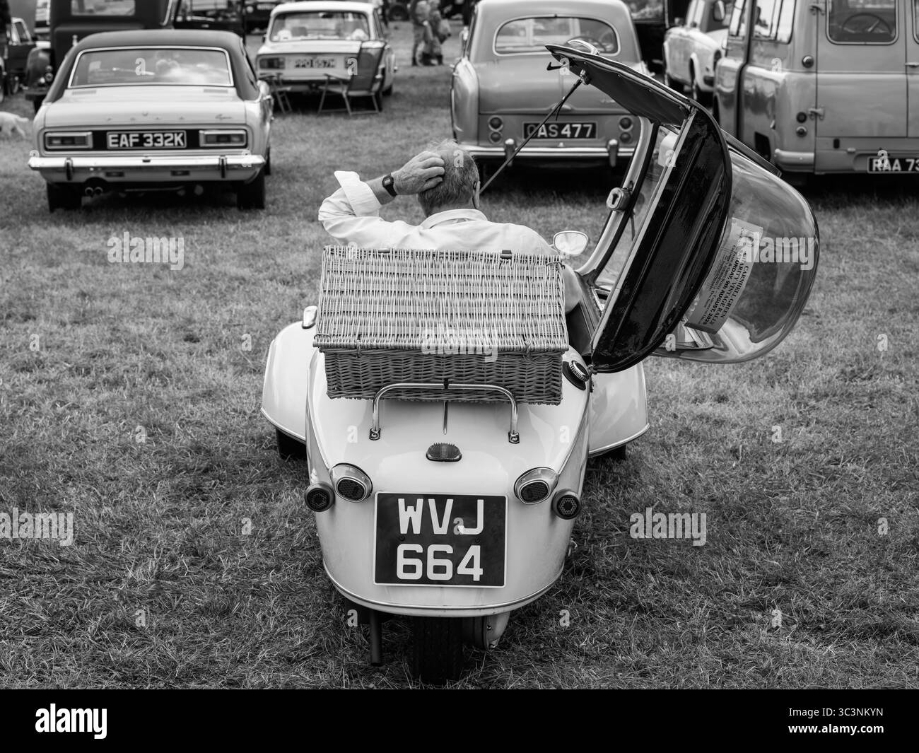 Homme dans la voiture bulle se grattant la tête au St Buryan Show 26 juillet 2025 Cornish Fayre Banque D'Images