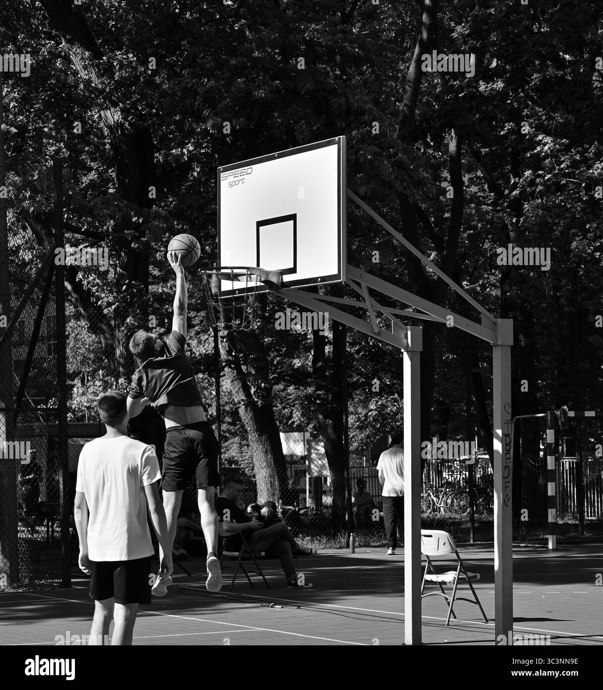 Basketball, jeunes jouant au basketball de rue. Attaque, basket-ball, image en noir et blanc, terrain de basket-ball, Varsovie, Pologne. Sport d'été. Banque D'Images