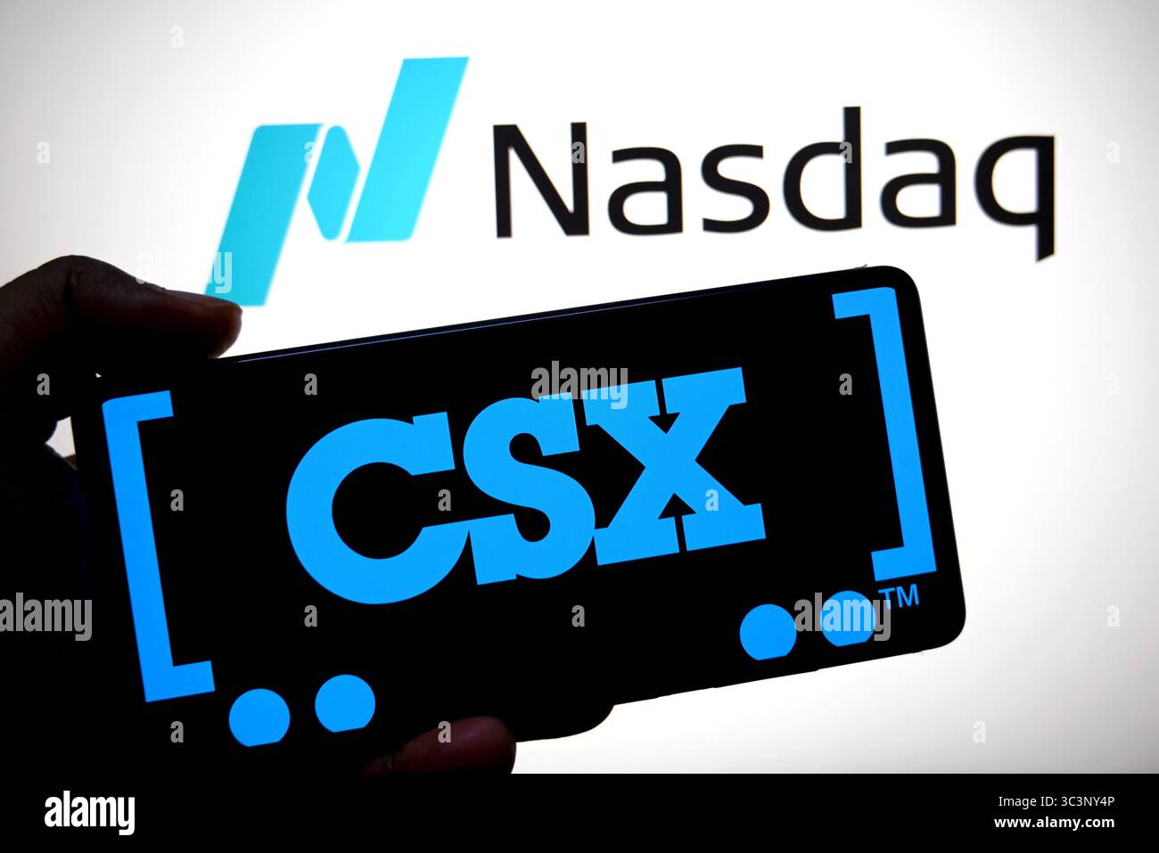 Dans cette illustration photo, un logo CSX est affiché sur un smartphone avec un logo NASDAQ en arrière-plan. Banque D'Images