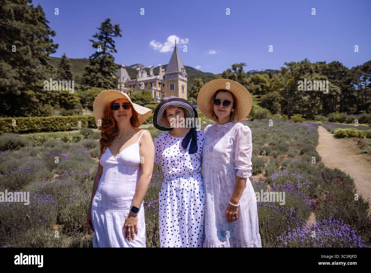 Trois femmes portant des chapeaux de paille posent dans un champ de lavande Banque D'Images