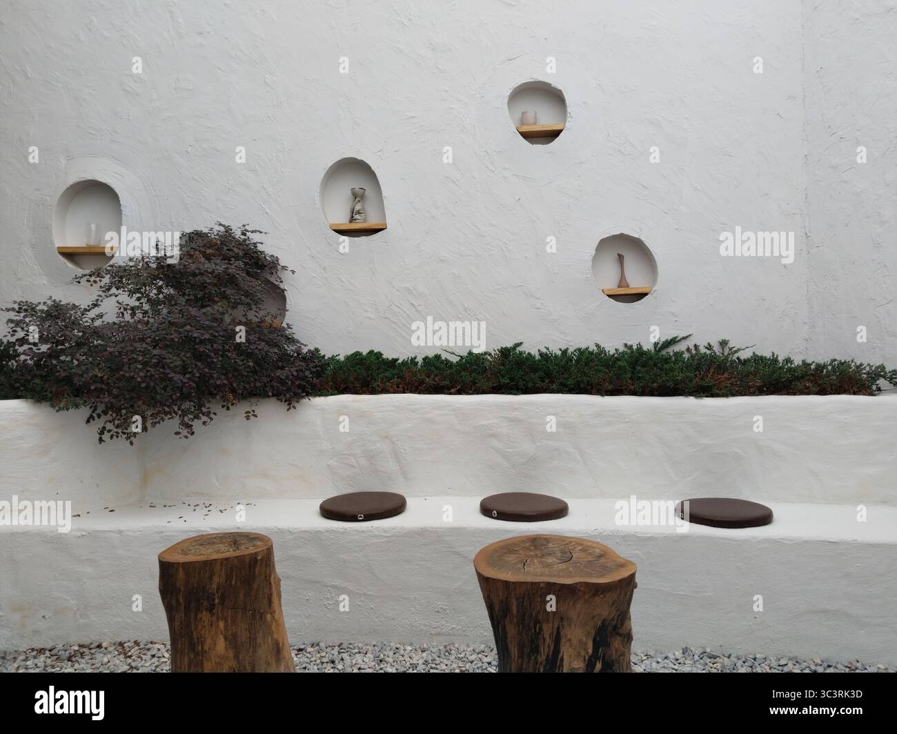 Espace dans une pièce décorée avec siège en bois et mur de texture de ciment blanc Banque D'Images
