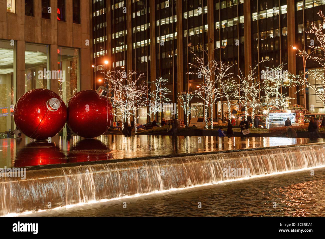 Boules rouges géantes et arbres étincelants pour Noël à New York Banque D'Images