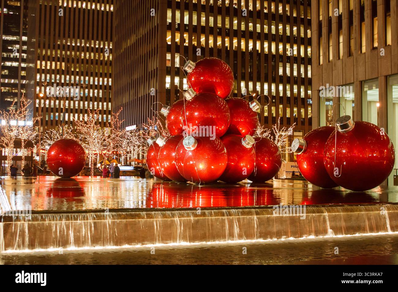 Boules rouges géantes et arbres étincelants pour Noël à New York Banque D'Images