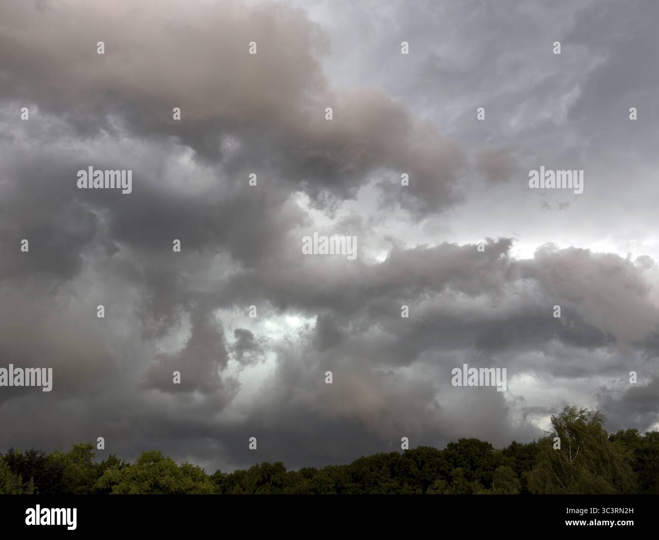 Nuages orageux sombres décolorés le roulis des nuages se déplace sur la zone forestière au-dessus des nuages gris les nuages de pluie annoncent des orages, Allemagne Banque D'Images