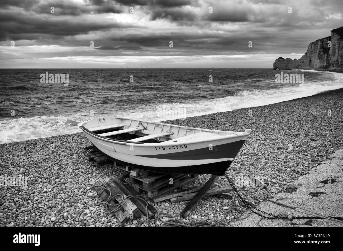 Bateau, bateau à rames, se trouve sur la plage, plage de galets, arche rocheuse falaise ou porte d'amont, Etretat, mer, nuages, côte escarpée, falaises, falaises de craie, alab Banque D'Images