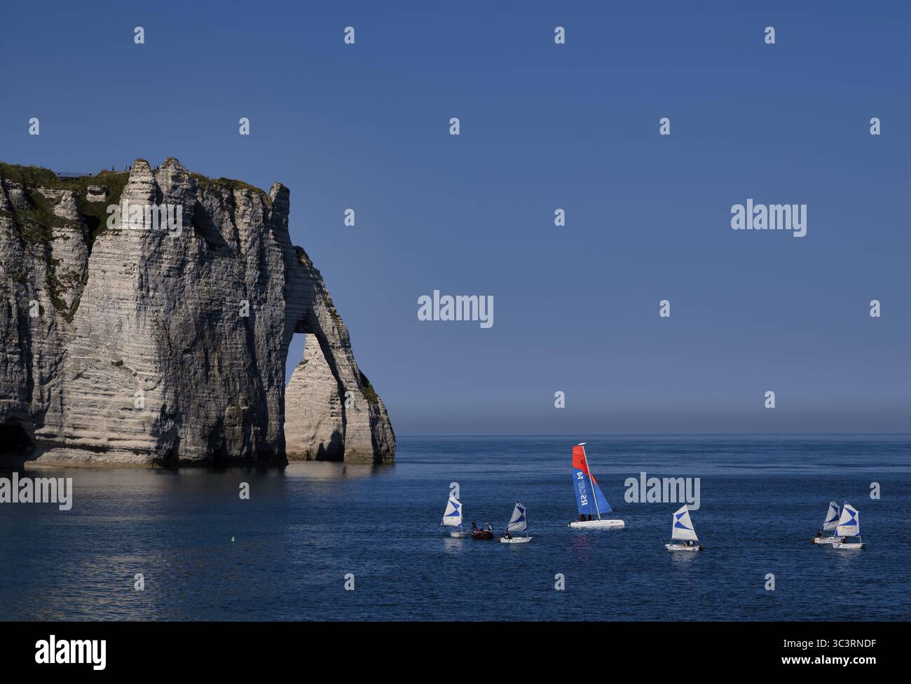 École de voile, voiliers, optimistes, arche rocheuse falaise ou porte d'aval, Etretat, mer, côte escarpée, falaises, falaises de craie, côte d'albâtre, la Co Banque D'Images