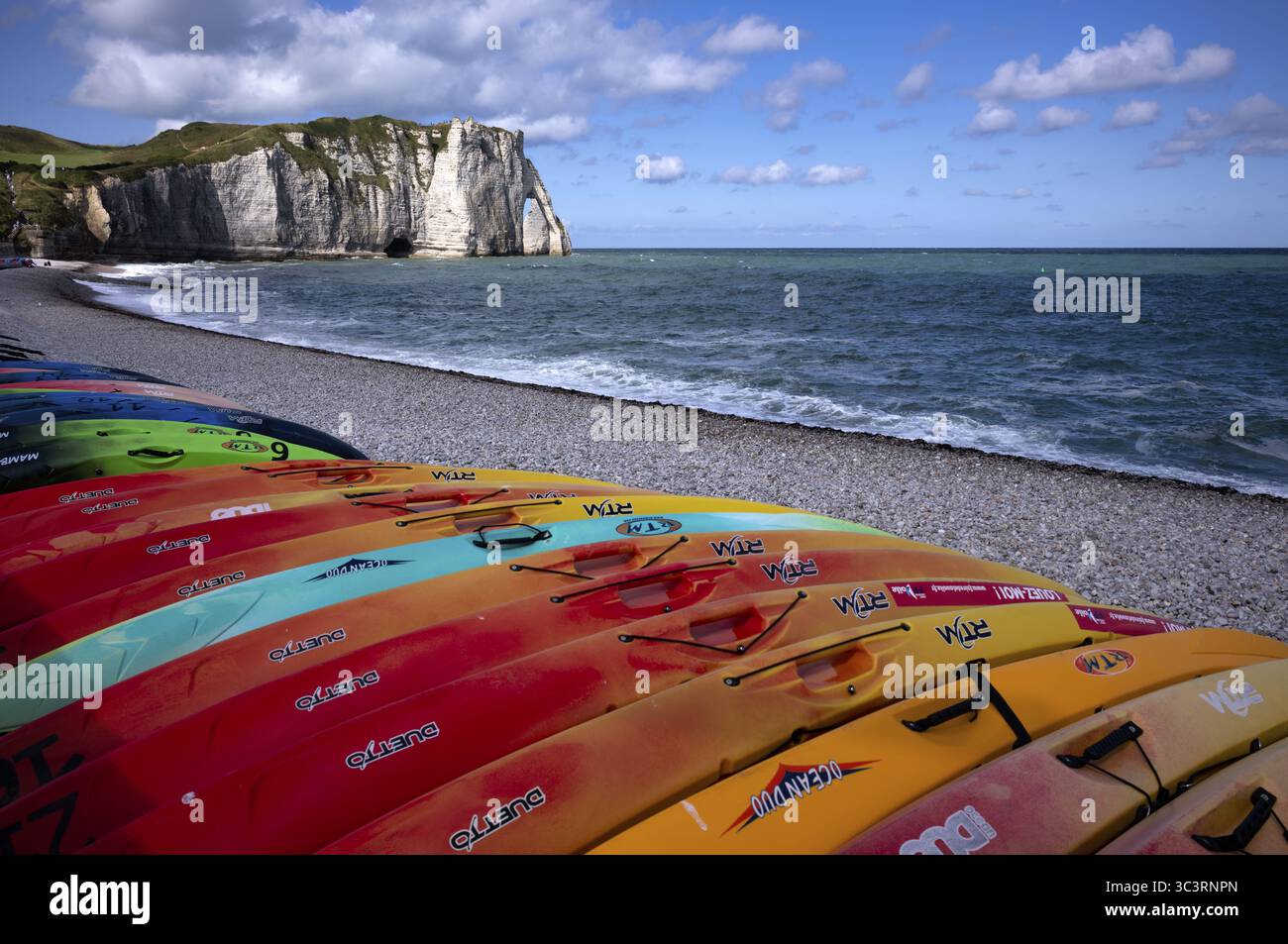 Kayaks, bateaux, colorés, couchés sur la plage, plage de galets, arche rocheuse falaise ou porte d'aval, Etretat, mer, côte escarpée, falaises, falaises de craie, alaba Banque D'Images