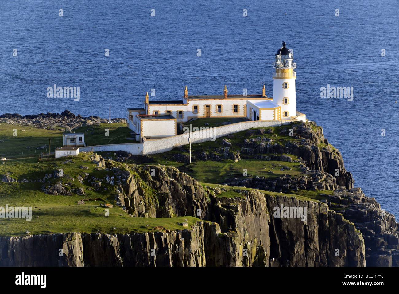 Neist point, île de Skye, Écosse, Grande-Bretagne, Europe, un phare se dresse sur le bord de falaises verdoyantes s'étendant dans la mer bleue Banque D'Images