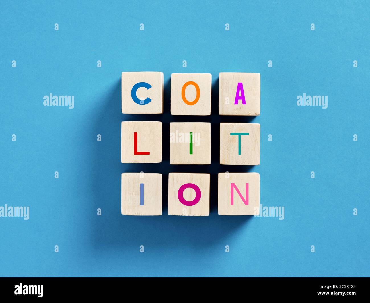 Les cubes en bois formant le mot coalition sur un fond bleu représentent le concept de partenariat. Banque D'Images