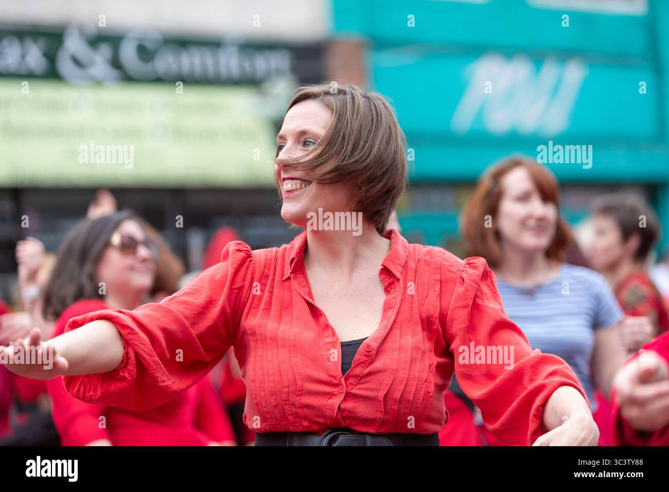 Birmingham, Royaume-Uni. 27 juillet 2025. Trois cents personnes se réunissent pour exécuter une routine de danse appelée Most Wuthering Heights Ever à Kings Heath, Birmingham, Royaume-Uni. Les participants, tous vêtus de rouge, ont été adressés par Jess Phillips, députée travailliste de Yardley, Birmingham, avant de recréer le clip de la chanson emblématique de Kate Bush, « Wuthering Heights ». Mme Phillips se joint à la danse expressive. L'événement amasse des fonds pour les éducatrices d'autonomisation des femmes et de rétablissement et les associations caritatives ANAWIM. Crédit : Peter Lopeman/Alamy Live News Banque D'Images