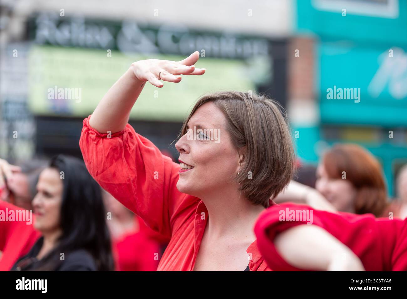 Birmingham, Royaume-Uni. 27 juillet 2025. Trois cents personnes se réunissent pour exécuter une routine de danse appelée Most Wuthering Heights Ever à Kings Heath, Birmingham, Royaume-Uni. Les participants, tous vêtus de rouge, ont été adressés par Jess Phillips, députée travailliste de Yardley, Birmingham, avant de recréer le clip de la chanson emblématique de Kate Bush, « Wuthering Heights ». Mme Phillips se joint à la danse expressive. L'événement amasse des fonds pour les éducatrices d'autonomisation des femmes et de rétablissement et les associations caritatives ANAWIM. Crédit : Peter Lopeman/Alamy Live News Banque D'Images