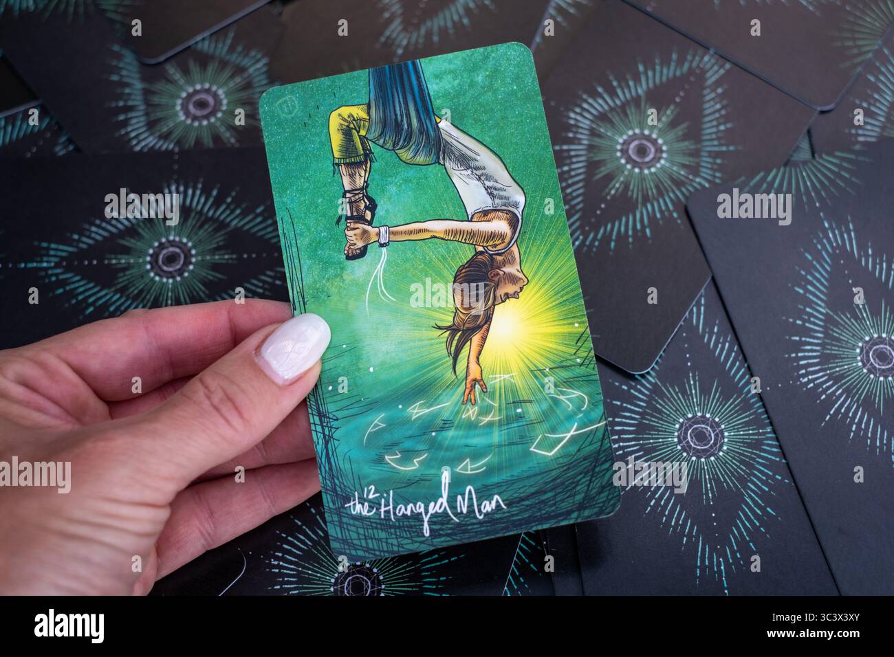 Carte de tarot « L’homme pendu » symbolisant l’abandon, la nouvelle perspective et l’éveil spirituel à travers le calme. Banque D'Images