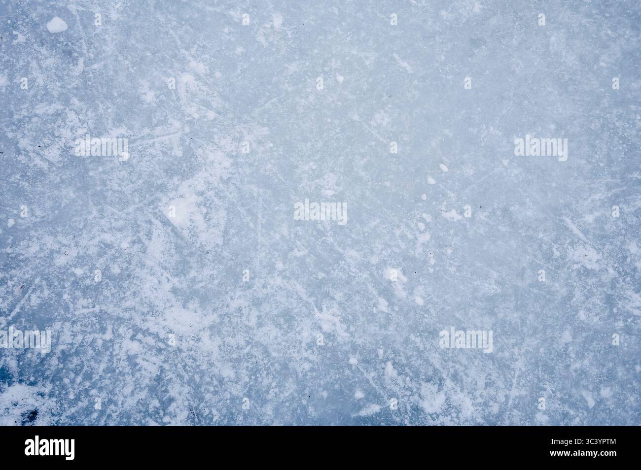 Gros plan de la surface de glace texturée avec des marques de neige et de rayures, un fond hivernal ou un résumé saisonnier Banque D'Images