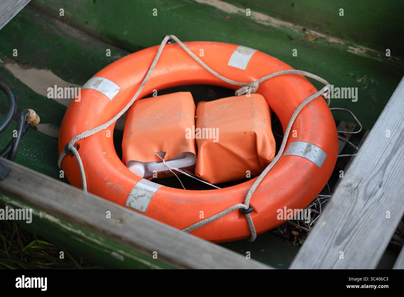 Un gilet de sauvetage orange vif doté d'une corde durable l'entourant, généralement utilisé pour la sécurité pendant les activités aquatiques Banque D'Images