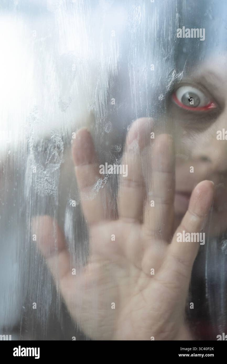 Main désespérée pressée sur du verre brumeux, femme floue derrière du verre cuit à la vapeur, tendre la main, isolement, détresse mentale, appel silencieux à l'aide, Su Banque D'Images