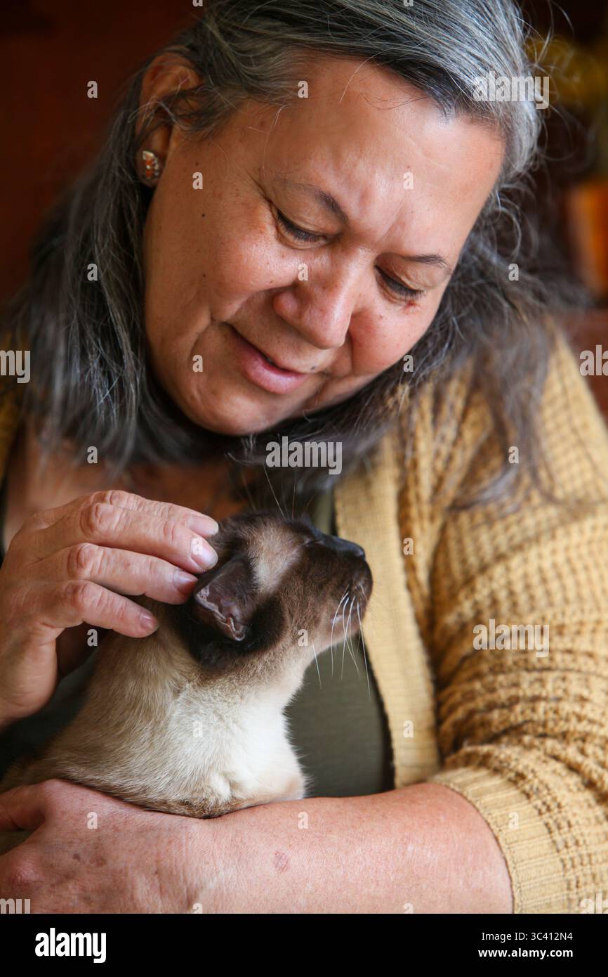 gros plan portrait d'une femme âgée latino tenant avec amour son chat à l'intérieur Banque D'Images