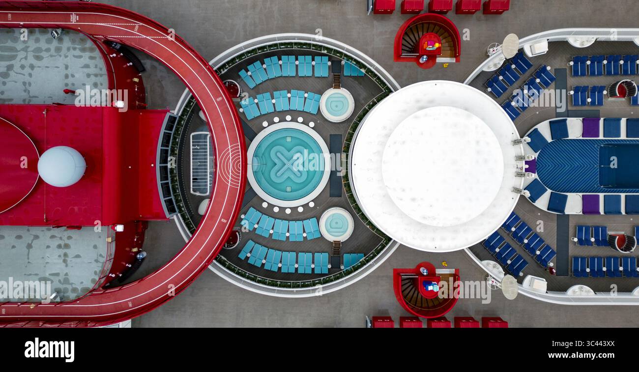 Vue aérienne d'un pont dynamique et géométrique avec une piste de course rouge, des chaises longues turquoise et une plate-forme centrale blanche créant une vue moderne et ludique, Split, comté de Split-Dalmatie, Croatie. Banque D'Images