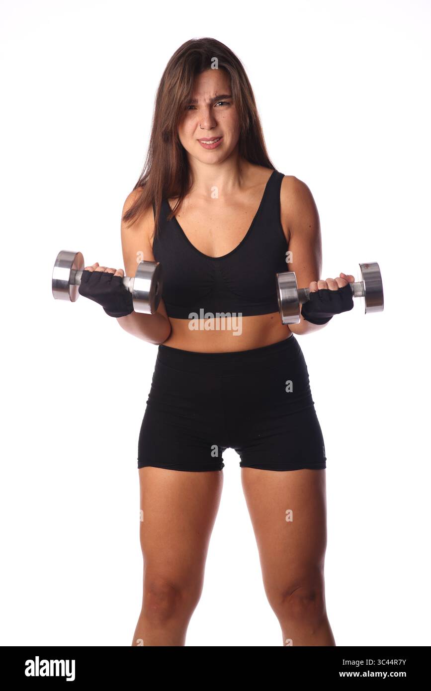 jeune femme confuse avec 2 haltères devant un fond blanc Banque D'Images
