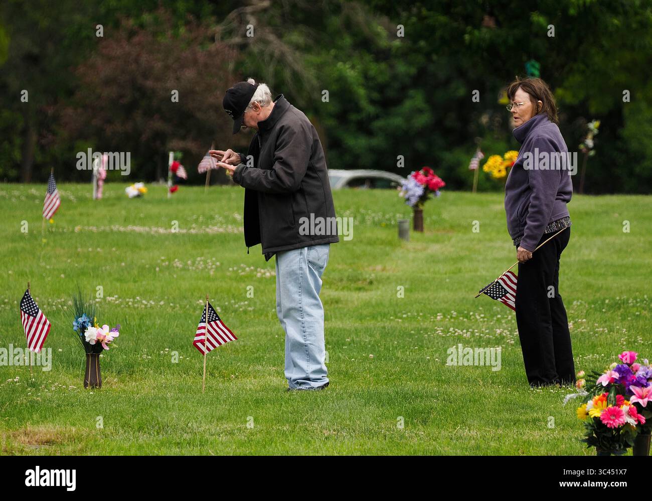 28 mai 2021, SIOUX CITY, IOWA, États-Unis : CRAIG HANSEN de Sioux Falls, SD, vérifie la mise au point sur l'appareil photo de son téléphone portable alors qu'il prend des photos des marqueurs funéraires de son père et d'un frère après que lui et sa femme, Claudia, ont mis des fleurs et des drapeaux américains en mémoire des membres de sa famille au cimetière Memorial Park à Sioux City, Iowa samedi 29 mai 2021. Les Hansen ont tous deux grandi à Sioux City. Au cours de la semaine, les forces de l'ordre locales et les membres de la Garde nationale de l'air de l'Iowa et de la Garde nationale de l'armée ont mis de petits drapeaux américains sur les tombes des anciens combattants. (Crédit image : © Jerry Mennenga/ZUMA Wire) Banque D'Images
