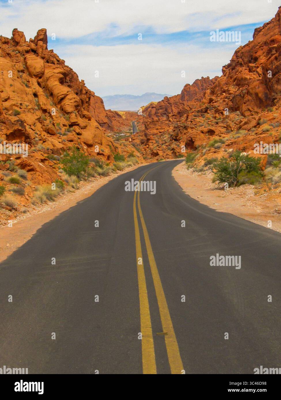 Route goudronnée traversant les rochers rouge foncé vif du parc national de la Valley of Fire dans le Nevada Banque D'Images