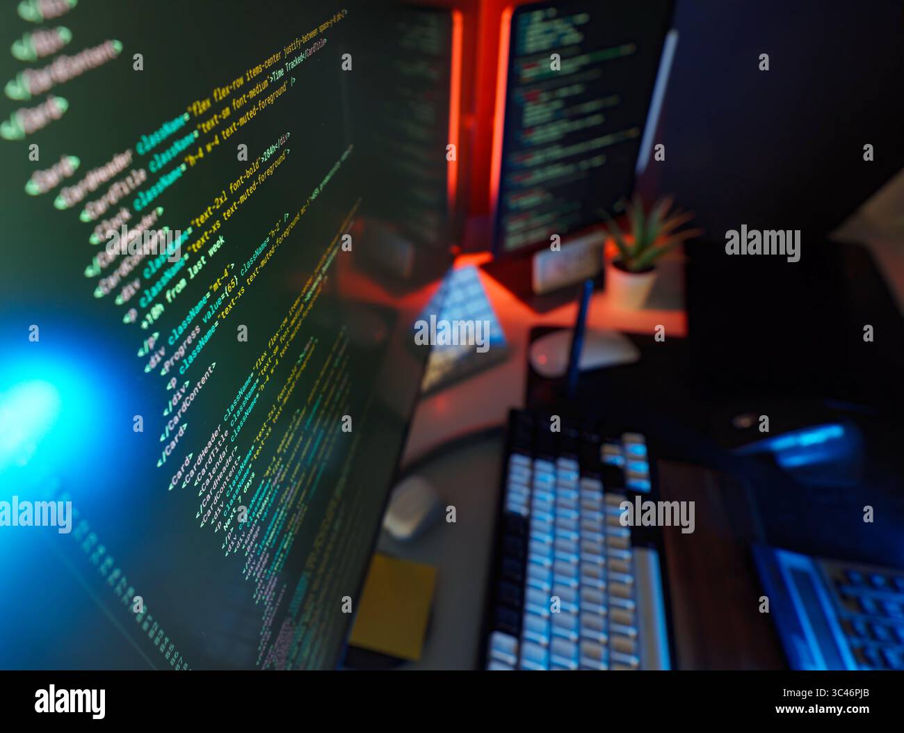 Studio numérique de station de travail à distance de cyber-codage avec lumières colorées, code à l'écran et périphériques modernes. Concept de travail éloigné futuriste, IT Banque D'Images