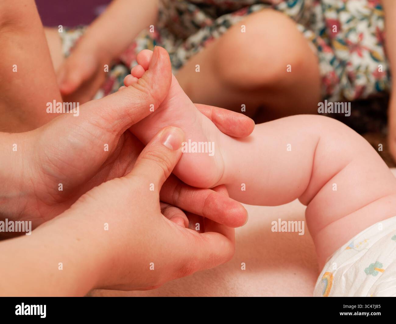 Massage des pieds pour bébés dans le cadre d'une séance de thalassothérapie au spa, gros plan sur le soin de bien-être des nourrissons. Banque D'Images