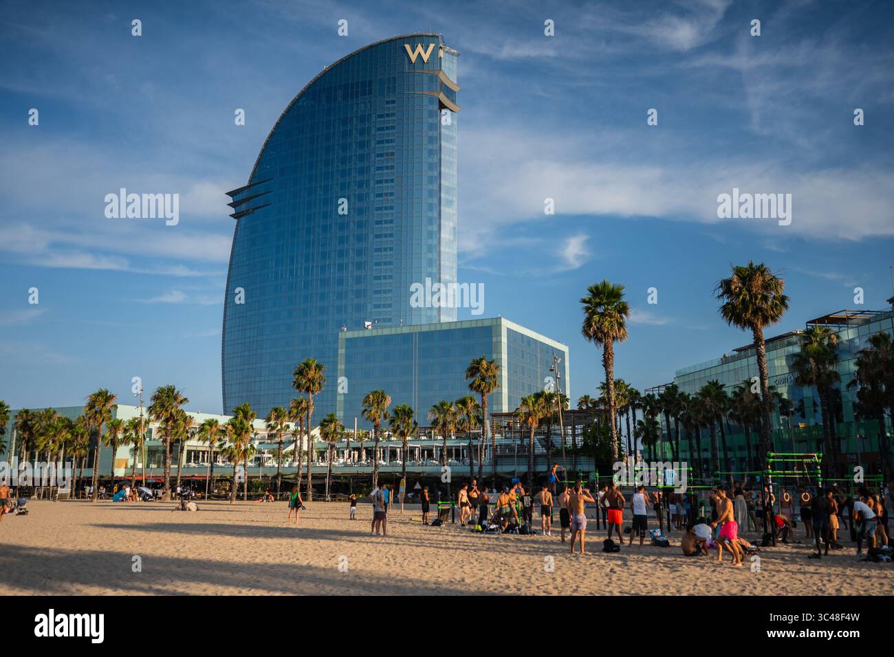 Promenade de la plage de Barceloneta avec l'Hôtel W en arrière-plan, Barcelone, Espagne Banque D'Images