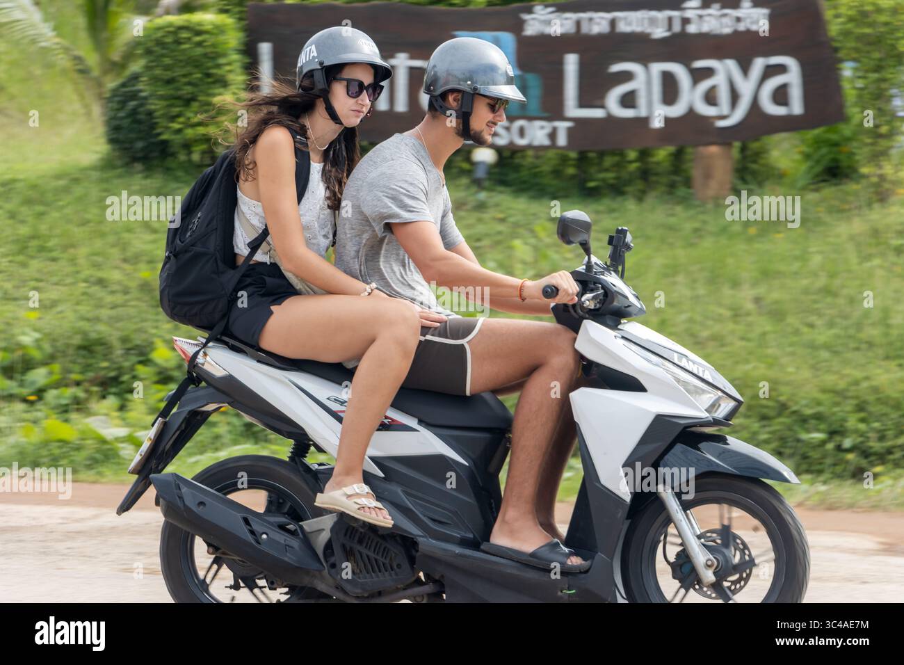 KOH LANTA, THAÏLANDE, DEC 01 2024, une paire de touristes conduisent une moto louée le long d'une route de campagne Banque D'Images