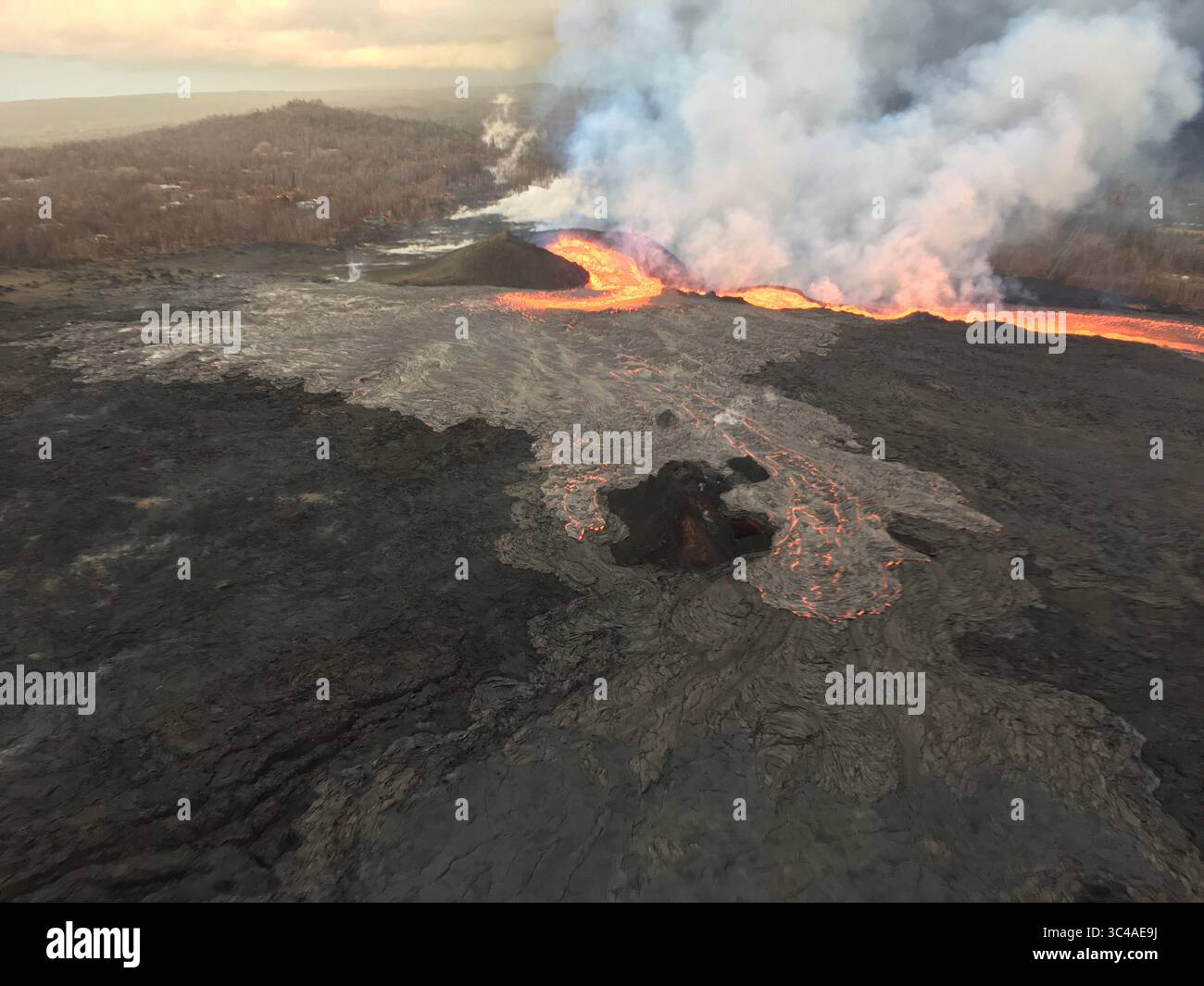 15 juillet 2018 - Hawaï, États-Unis - vue de la fissure 8 regardant le haut vers l'ouest. Le canal de lave ouvert en haut à droite mène à l’océan ; lorsque la photo a été prise ce matin tôt, presque toute la lave en éruption de la fissure 8 était dans le canal. Une partie de lave se déversait vers l’est pour former un flux avançant lentement (au milieu du premier plan) au sommet des coulées de lave antérieures. Ce flux s'est calé en quelques heures. (Crédit image : © USGS/ZUMA Wire/ZUMAPRESS.com) Banque D'Images