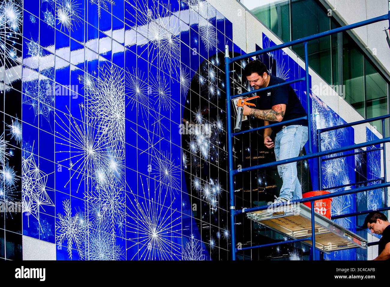 27 juillet 2018 - St Petersburg, Floride, États-Unis - CHERIE DIEZ | Times .Marcelo de Cicco, à gauche, de Mato Grosso, Brésil et Bruno Sousa de Brasilia, Brésil terminent l'installation de ''The invisible Telescope''' de la célèbre artiste brésilienne Sandra Cinto sur les murs extérieurs de la collaboration Terrace au troisième étage du Lynn Pippenger Hall, au Kate Tiedemann College of Business, USFSP, vendredi 27 juillet 2018. L'œuvre a été conçue spécifiquement pour l'emplacement et peut être vue à travers les veuves de verre aux deuxième, troisième et quatrième étages. Il est situé dans une zone appelée Scholar's Garden. . CH Banque D'Images