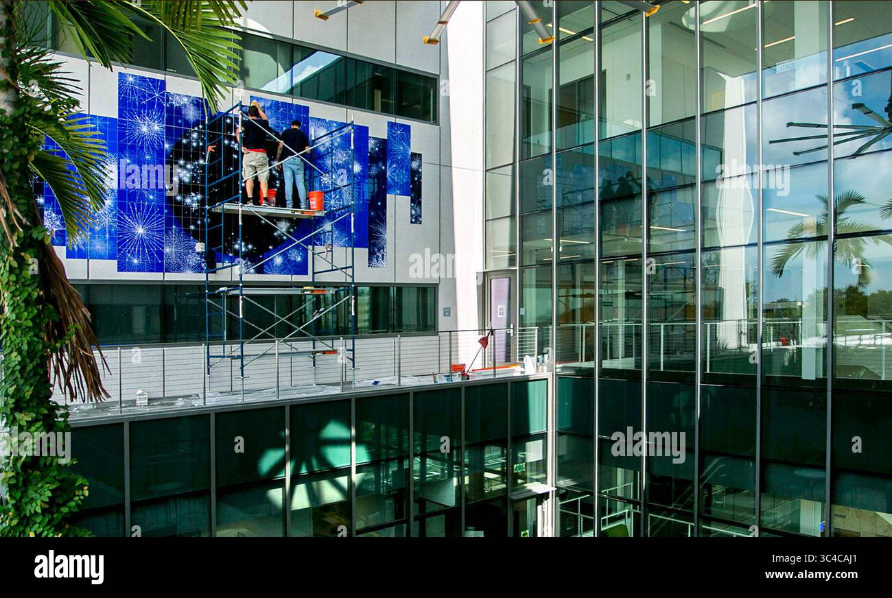 27 juillet 2018 - St Petersburg, Floride, États-Unis - CHERIE DIEZ | Times .Bruno Sousa, à gauche, de Brasilia, Brésil, et Marcelo de Cicco, de Mato Grosso, Brésil terminent l'installation de ''The invisible Telescope''' de la célèbre artiste brésilienne Sandra Cinto sur les murs extérieurs de la collaboration Terrace au troisième étage du Lynn Pippenger Hall, au Kate Tiedemann College of Business, USFSP, vendredi 27 juillet 2018. L'œuvre a été conçue spécifiquement pour l'emplacement et peut être vue à travers les veuves de verre aux deuxième, troisième et quatrième étages. Il est situé dans une zone appelée Scholar's Garden. ( Banque D'Images