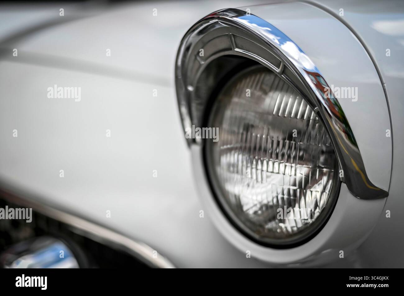 Gros plan détaillé d'un phare Ford Thunderbird 1955, pris lors d'un événement de voitures anciennes à Kitchener, Ontario, Canada. Juillet 2025 Banque D'Images