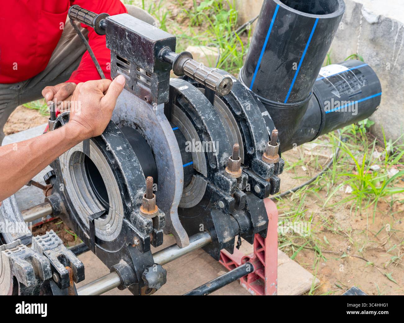 Le technicien effectue une soudure bout à bout sur des tuyaux en PEHD à l'aide d'une machine de soudure bout à bout. Banque D'Images