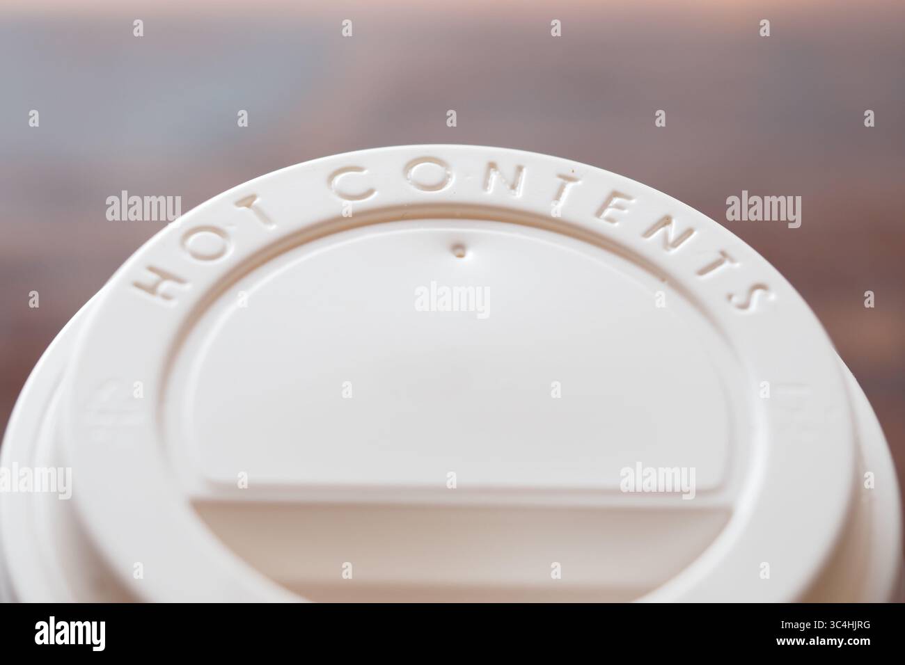 Un gros plan d'un couvercle de boisson a révélé un avertissement concernant le contenu chaud à l'intérieur Banque D'Images