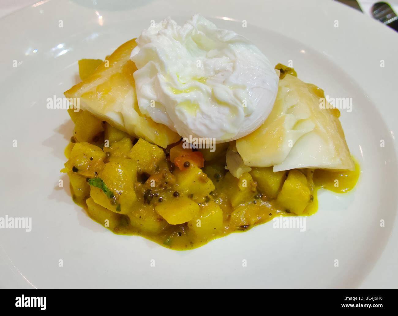 Curry de pommes de terre doux avec haddock fumé et oeuf poché Rick Stein TV Chef The Seafood Restaurant Padstow Cornwall Angleterre Royaume-Uni Europe Banque D'Images