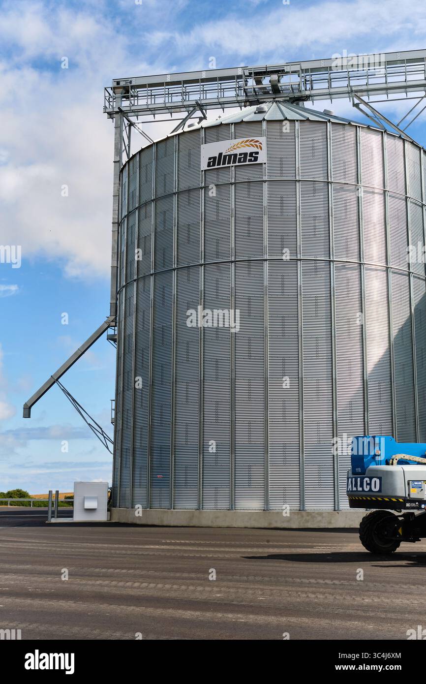 23 juillet 2025 – Ystad-Suède : énorme silo à céréales de la marque Almas et une partie d'un stand de levage de rampe Rallco sur de l'asphalte fraîchement pavé dans une ferme et const Banque D'Images