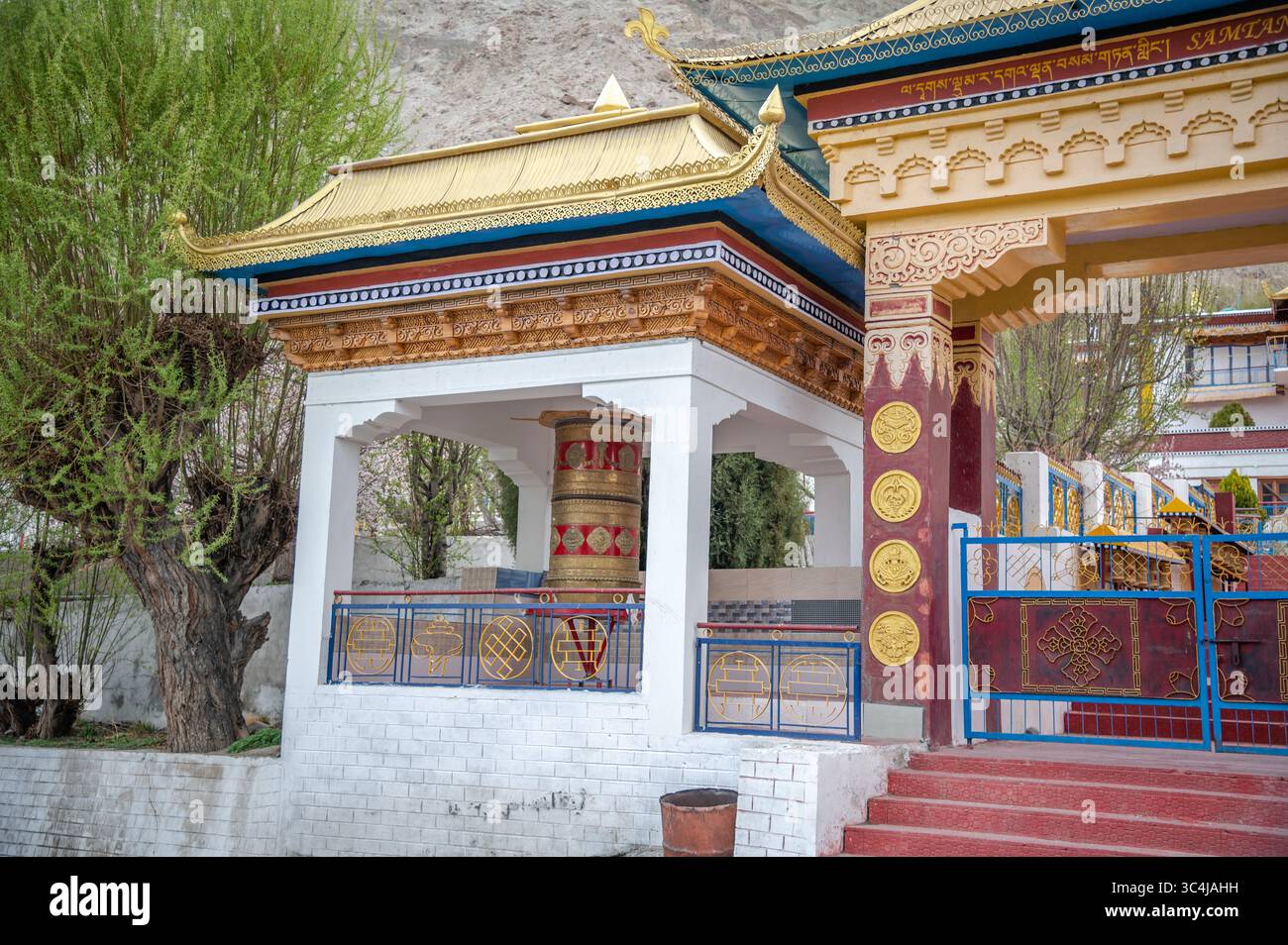 Roue à prières bouddhiste traditionnelle à l'extérieur d'un monastère, symbole de foi et de spiritualité, utilisée pour la méditation et le chant de mantras. Banque D'Images