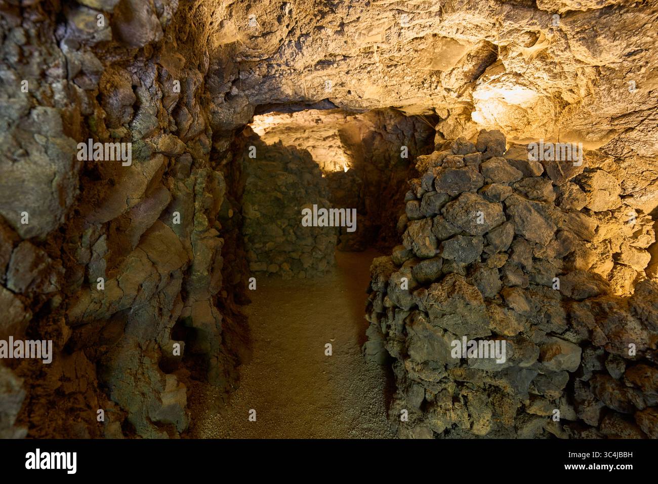 Intérieur d'une grotte volcanique formée par un ancien tube de lave avec des murs en pierre brute et un éclairage tamisé Banque D'Images