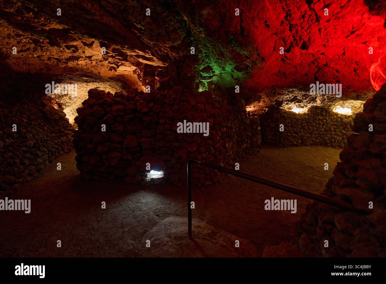 Intérieur d'une grotte volcanique formée par un ancien tube de lave avec des murs en pierre brute et un éclairage tamisé Banque D'Images