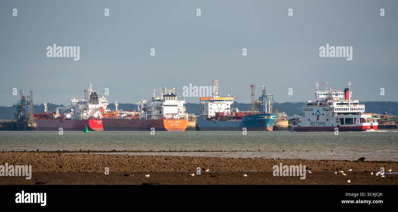Fawley Southampton Water Angleterre Royaume-Uni. 26.07.2025. Ferry roro de l'île de Wight passant devant des navires amarrés sur Southampton Water, au sud de l'Angleterre, Royaume-Uni. Banque D'Images