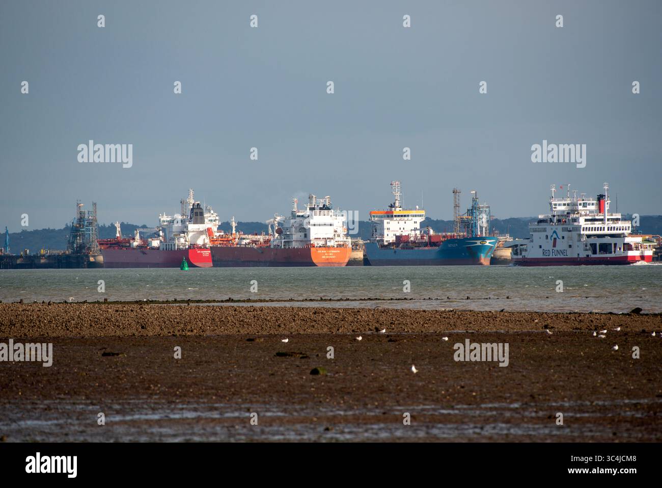 Fawley Southampton Water Angleterre Royaume-Uni. 26.07.2025. Ferry roro de l'île de Wight passant devant des navires amarrés sur Southampton Water, au sud de l'Angleterre, Royaume-Uni. Banque D'Images