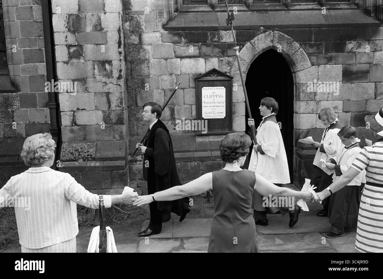 Wirksworth Derbyshire St Marys Church Clipping. La congrégation tient les mains en cercle autour de toute l'église. Le mot 'clipping' est d'origine anglo-saxonne, et est dérivé du mot 'clyp-pan', signifiant 'embrasser' ou 'fermoir' et est donc une expression de dévotion. Angleterre des années 1970 Royaume-Uni HOMER SYKES Banque D'Images