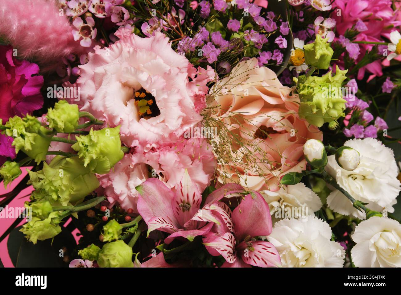 Un bouquet floral aux couleurs vives en gros plan. Œillets, eustoma, alstromeria. Banque D'Images