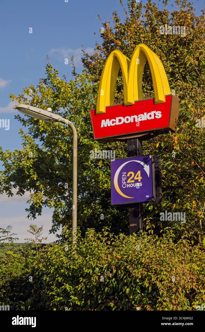 Basingstoke, Royaume-Uni - 27 octobre 2024 : panneau de couleurs vives à l'extérieur des 24 heures de route du restaurant McDonald's sur le site du parc de loisirs de Basings Banque D'Images
