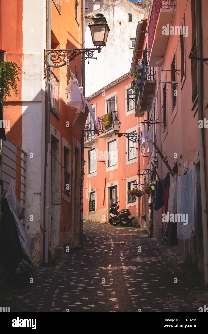 Lisbonne, Portugal - 15 mai 2025 : les pavés dans une ruelle étroite brillent au début de la lumière du soleil Banque D'Images