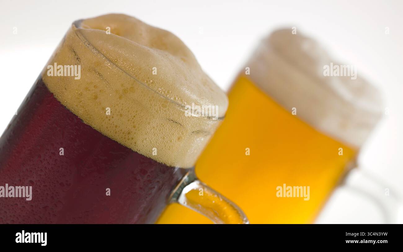 Deux tasses de bière foncée et légère avec mousse Banque D'Images