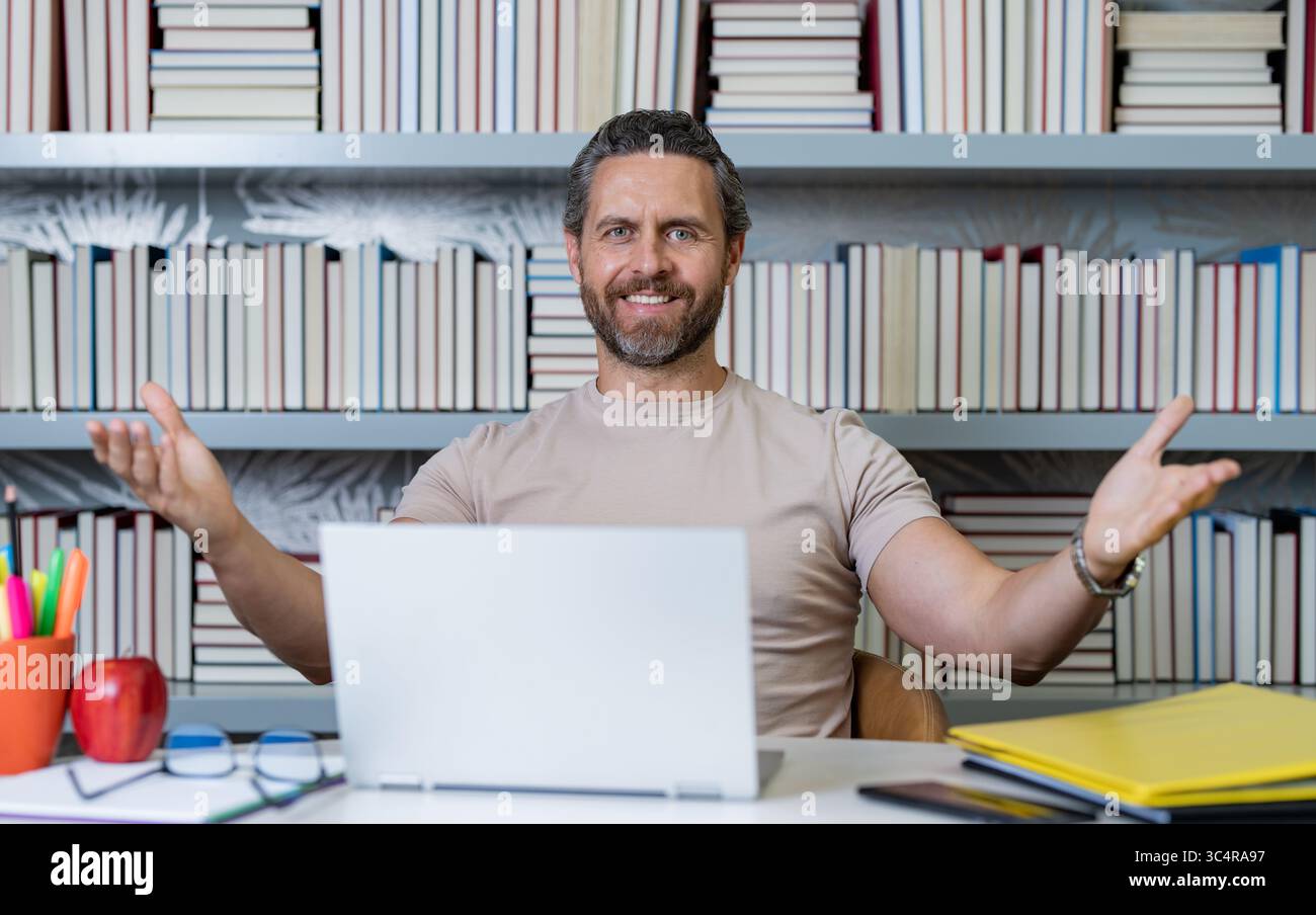 Enseignant travail sur ordinateur portable en classe. Connaissance et éducation avec beau professeur. Professeur avec livre en classe. Homme en leçon en classe. Enseignants Banque D'Images