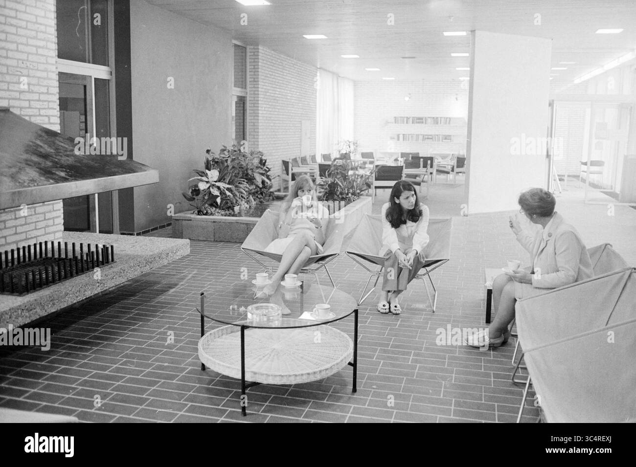 Intérieur de la maison sœur à Beverwijk, intérieur, hôpitaux, 24-06-1970 Whizgle News, Dutch Desk, pays-Bas, 1950-2000 Un salon moderne comprend trois femmes assises dans des chaises élégantes, engageant la conversation près d'une cheminée unique. La chambre spacieuse est ornée de plantes en pot et présente un design minimaliste, mettant en valeur un mélange d'élégance décontractée et de confort. Un service à café est disposé sur une table ronde, améliorant l'atmosphère accueillante. Banque D'Images Intérieur de la maison sœur à Beverwijk, intérieur, hôpitaux, 24-06-1970 Whizgle News, Dutch Desk, pays-Bas, 1950-2000 Un salon moderne comprend trois femmes assises dans des chaises élégantes, engageant la conversation près d'une cheminée unique. La chambre spacieuse est ornée de plantes en pot et présente un design minimaliste, mettant en valeur un mélange d'élégance décontractée et de confort. Un service à café est disposé sur une table ronde, améliorant l'atmosphère accueillante. Banque D'Images