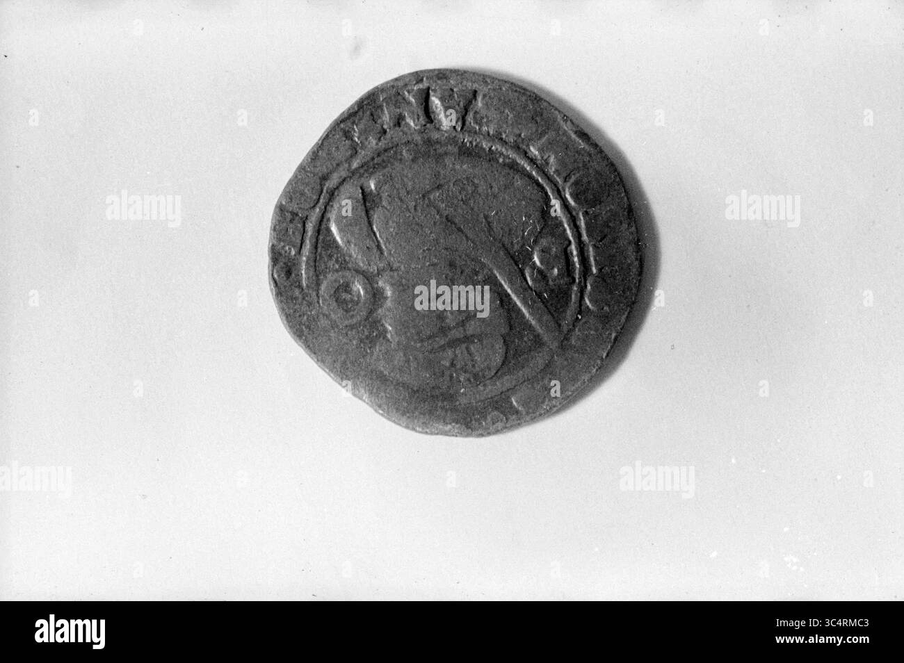 Old coin, Money, 17-09-1963 Whizgle News, Dutch Desk, pays-Bas, 1950-2000 une pièce de monnaie ancienne comportant un dessin détaillé, représentant peut-être une figure ou un emblème, enfermée dans une bordure circulaire. La surface montre des signes d'usure, suggérant sa signification historique. Banque D'Images